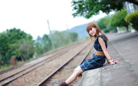 女孩坐在铁路附近