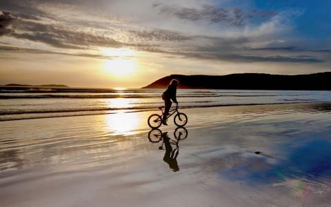 自行车在海滩上的女孩